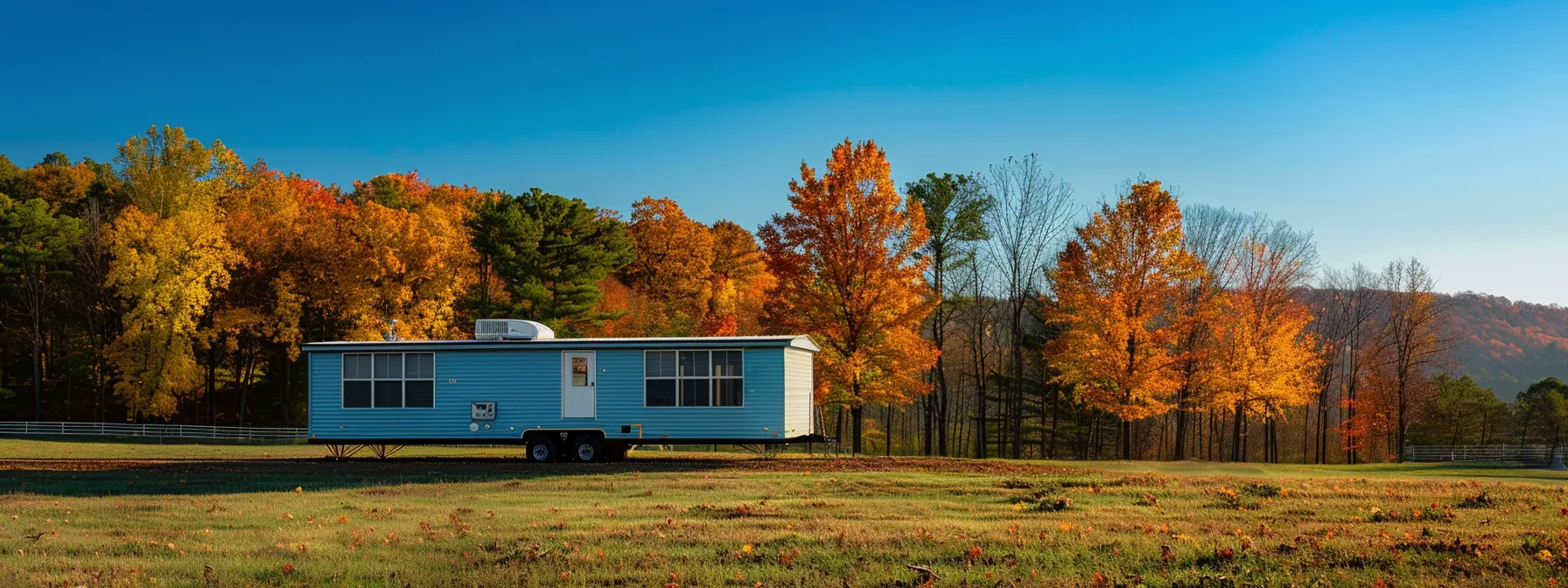 a powerful mobile home mover navigating a scenic virginia landscape, showcasing vibrant autumn foliage against a clear blue sky.